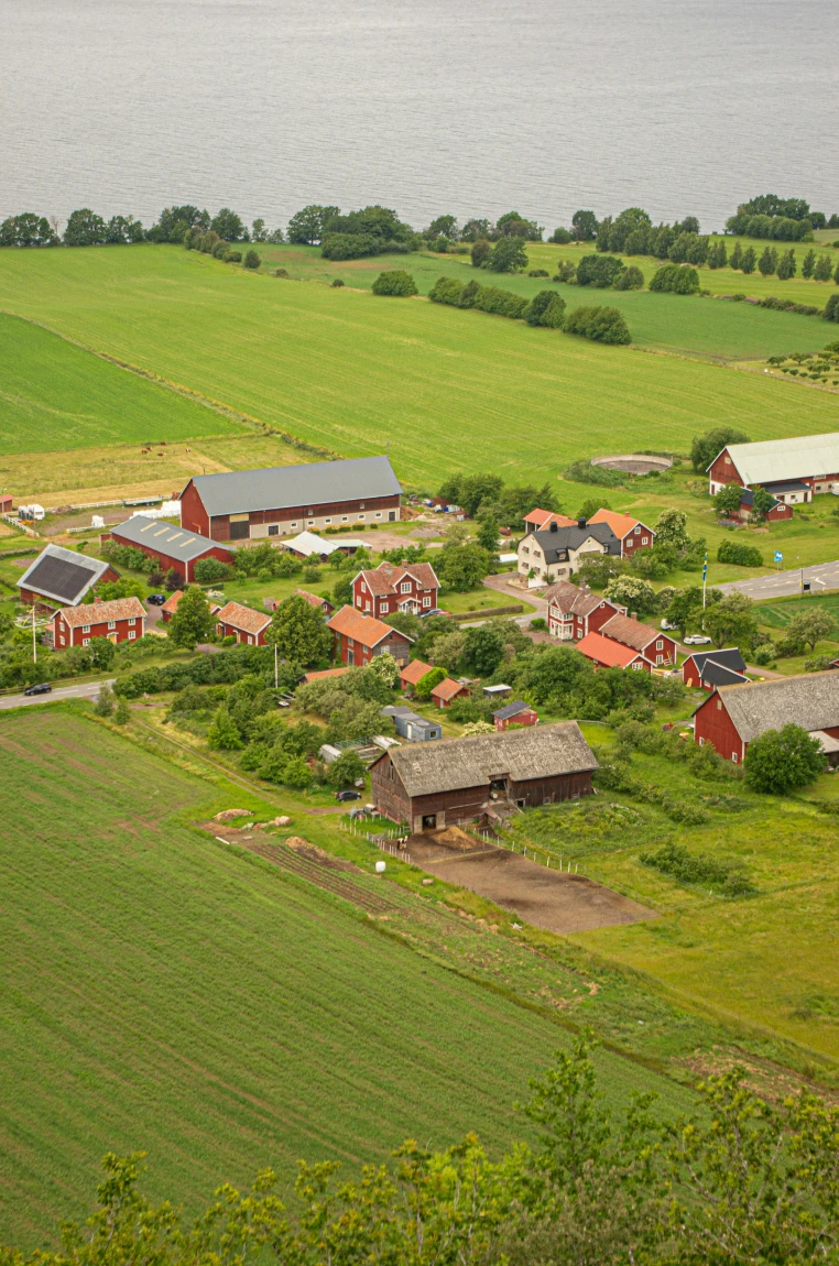 Utsikt över en svensk landsbygd med gårdar nära en sjö